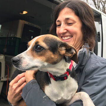 SAVE.DOG pup & employee smiling for the camera